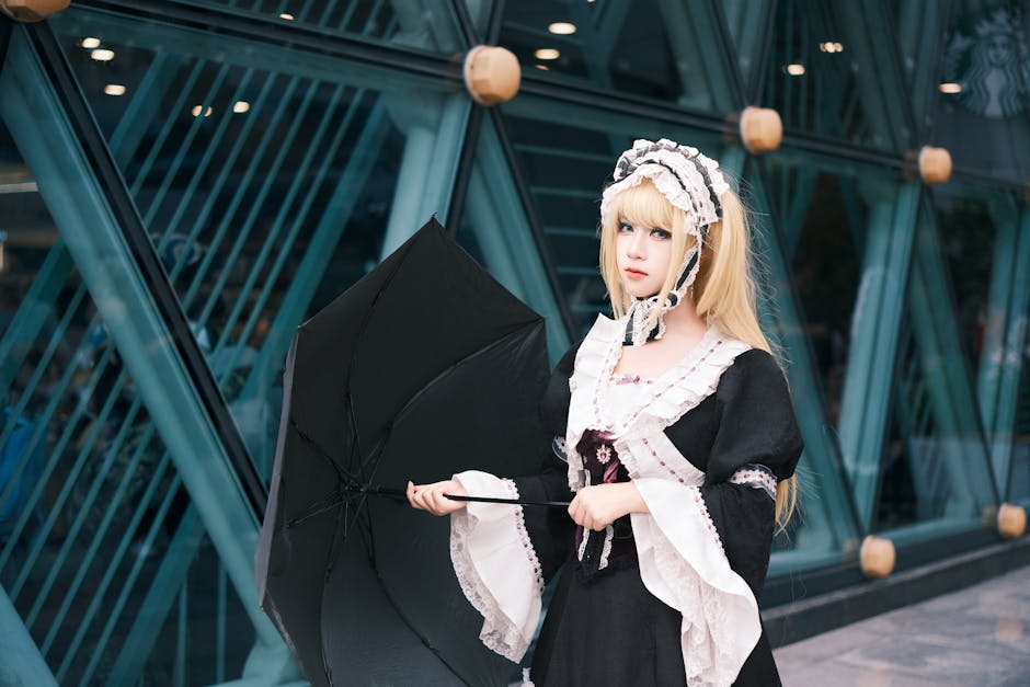 コスプレ衣装を着た若い女性が、近代的な建物の外で傘を差している。
