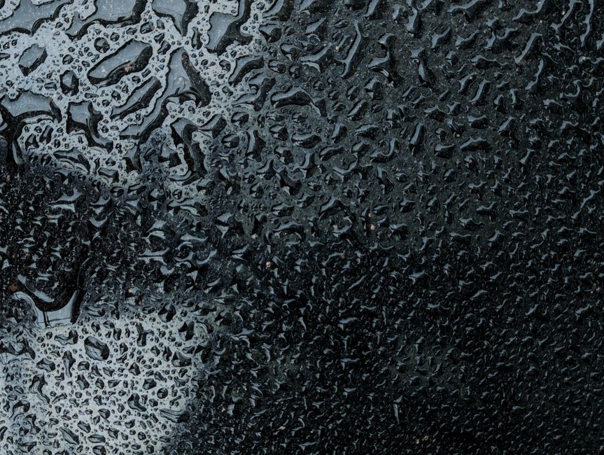 バングラデシュのダッカで撮影された、暗い背景に複雑な模様を描く雨滴。